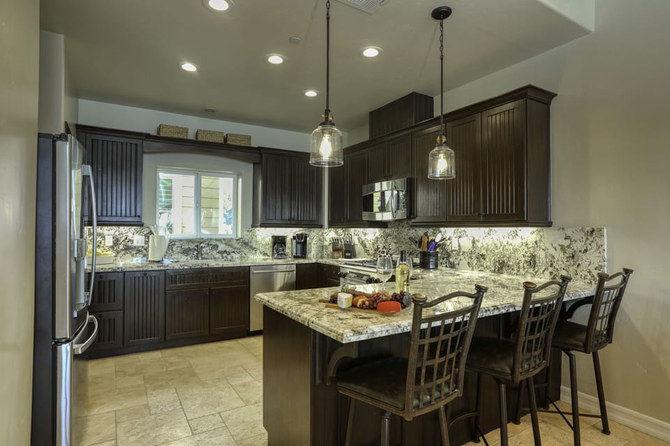 Granite countertops throughout the kitchen and bar seating to accommodate three guests.