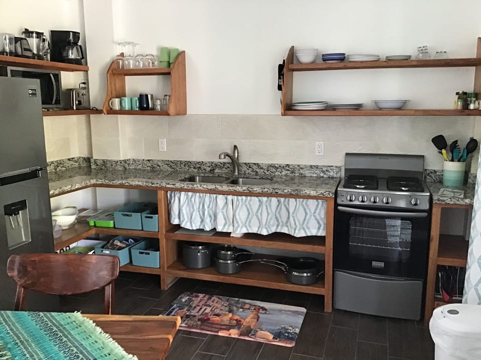 A fully stocked kitchen. Refrigerator, stove, coffee pot, plates-we have it all.