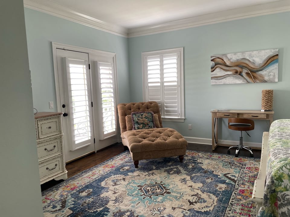Mstr has large screen TV, large dresser, door that leads to around porch