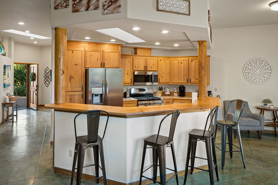 The bright kitchen features bar seating and a stocked Keurig coffee station.