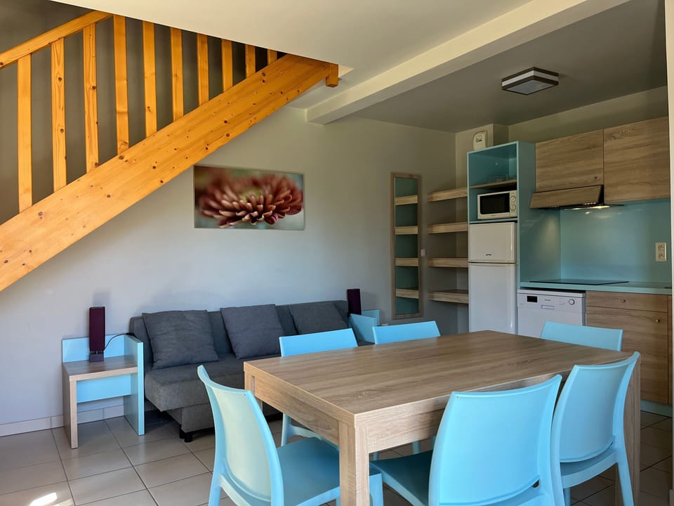 Dining table for 4 on the lower level, with the staircase leading up to the bedrooms — a fun layout for families.