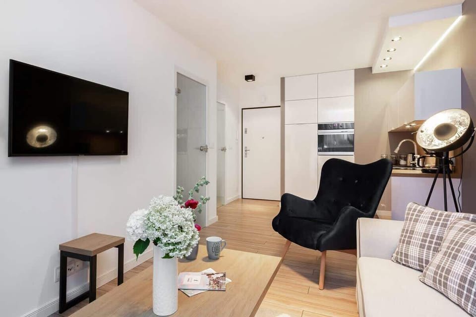 A modern, comfortable living room with a beige sofa, coffee table, and stylish decor pieces. Large windows bring in plenty of light, making it a bright and inviting space.