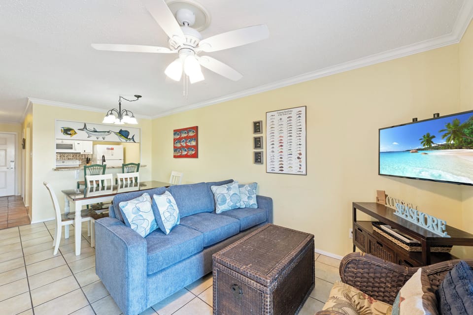 Unwind in your bright, coastal-themed living space with comfortable seating and entertainment center perfect for relaxing evenings.