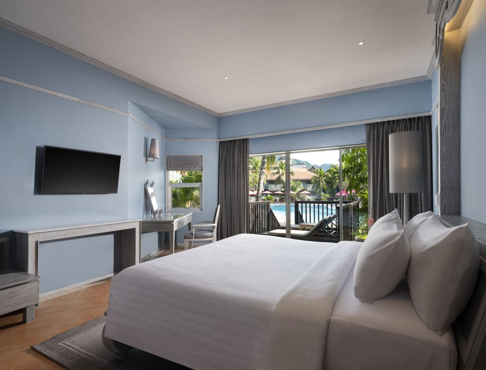 Deluxe Pool View | Minibar, in-room safe, desk, blackout drapes