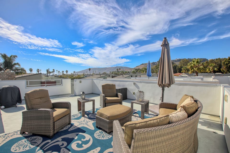 The expansive rooftop deck is the crown jewel of this modern villa condo, offering panoramic views of the sparkling Pacific Ocean and the charming town of Avila Beach.