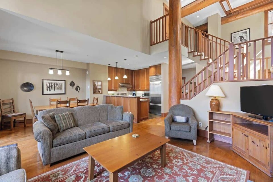- Open-concept living area with cozy seating and mountain lodge charm  
- Warm wood accents and natural light highlight the spacious layout  
- Ideal for relaxing, socializing, and connecting by the fire  
