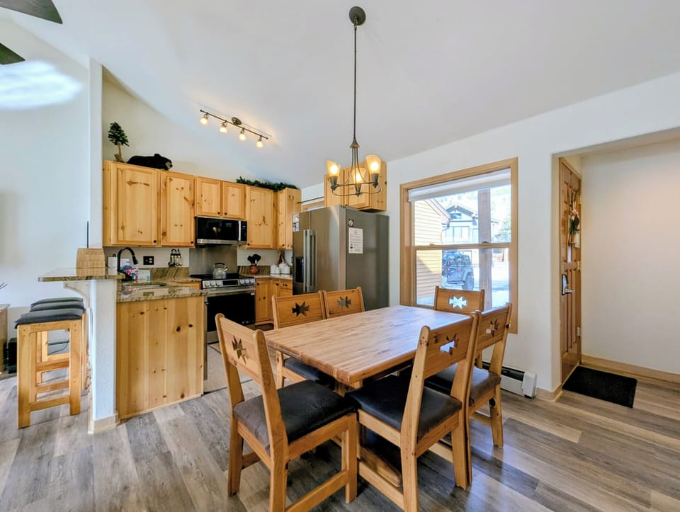 Your cozy dining space features warm wood furnishings and connects seamlessly to the fully equipped kitchen for memorable meals together.
