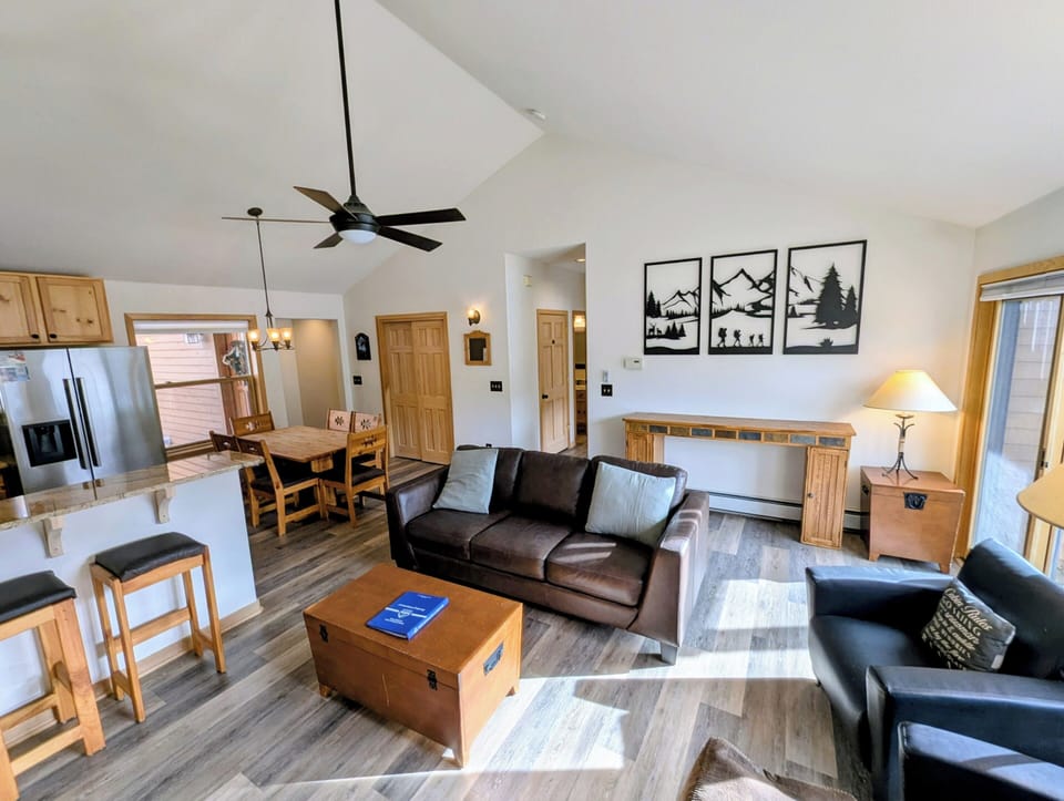 Unwind in your spacious open-plan retreat with comfortable leather seating, rustic wood accents, and mountain artwork that brings the outdoors inside.