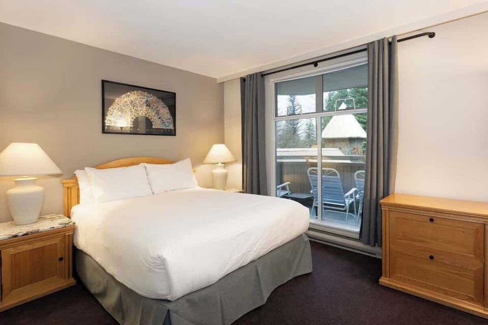 - Spacious bedroom with private balcony mountain views  
- Relax in a king bed retreat after your Whistler adventure  
- Warm decor ideal for couples seeking alpine tranquility  
