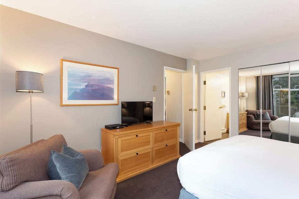 - Cozy bedroom with plush bedding and mountain view mirror  
- Relax in comfort after exploring Whistler’s scenic trails  
- Perfect retreat offering calm and cozy alpine ambiance  