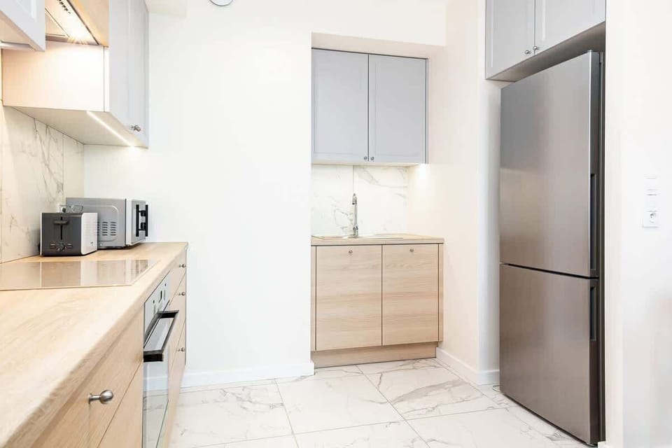 A modern kitchen featuring wooden cabinets, a stovetop, and a clean backsplash. The area feels warm and functional.