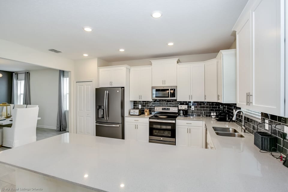 - Sleek Kitchen of the Home in Florida - This Kitchen blends style with functionality - Offering a refined space to unleash culinary creativity -  Sleek stainless steel appliances