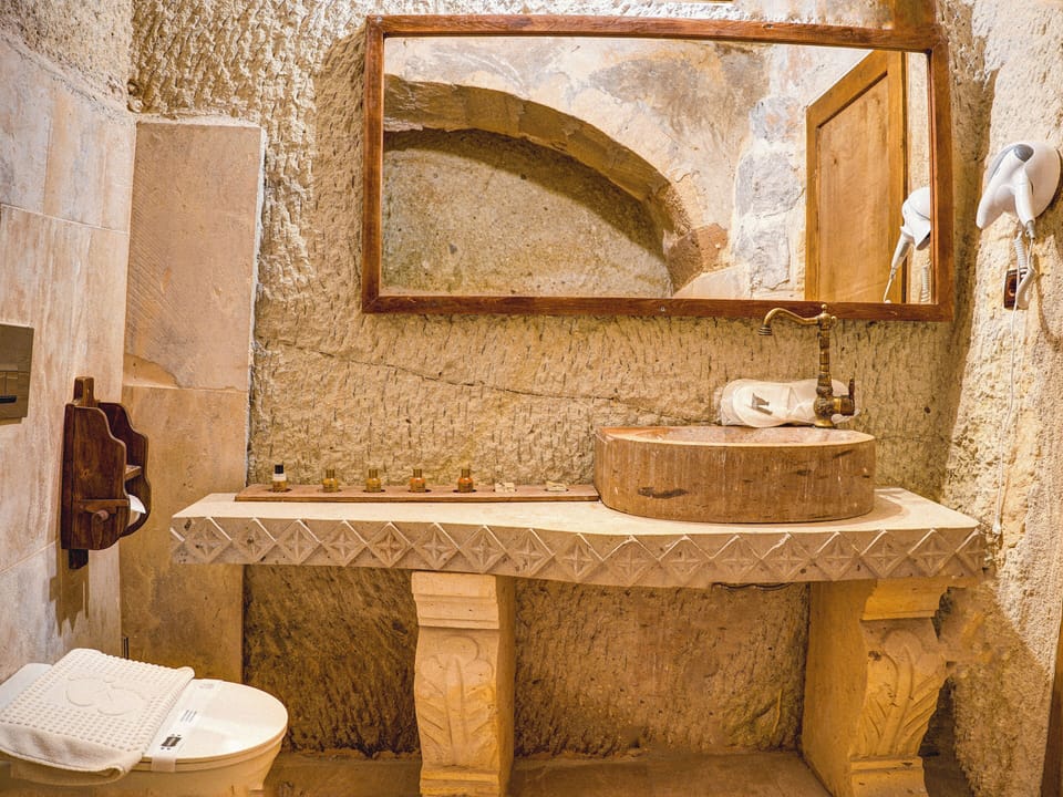 Defne Cave Honeymoon Suite | Bathroom | Designer toiletries, hair dryer, slippers, towels