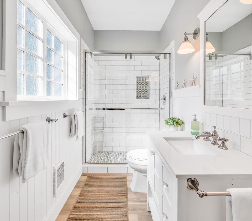 Refresh in a spotless bathroom with a glass-enclosed shower, clean white subway tile, and plush towels ready for your use.
