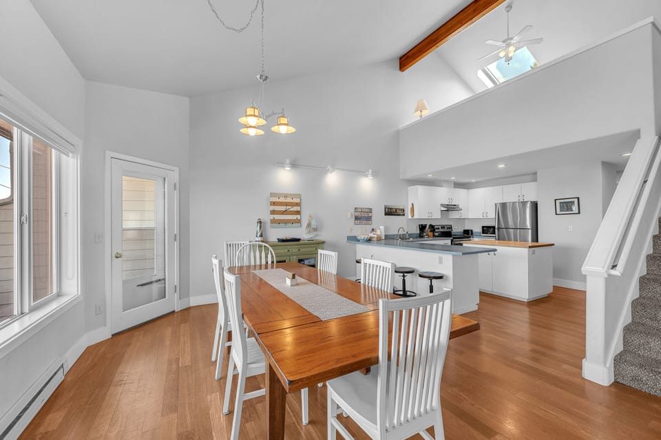 Gather around your spacious dining table in this bright, open-concept space with vaulted ceilings and warm wood floors for memorable meals together.