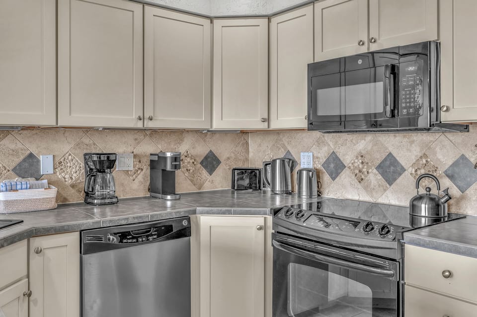 Your fully equipped kitchen features modern appliances and elegant tile backsplash, perfect for preparing meals during your stay.