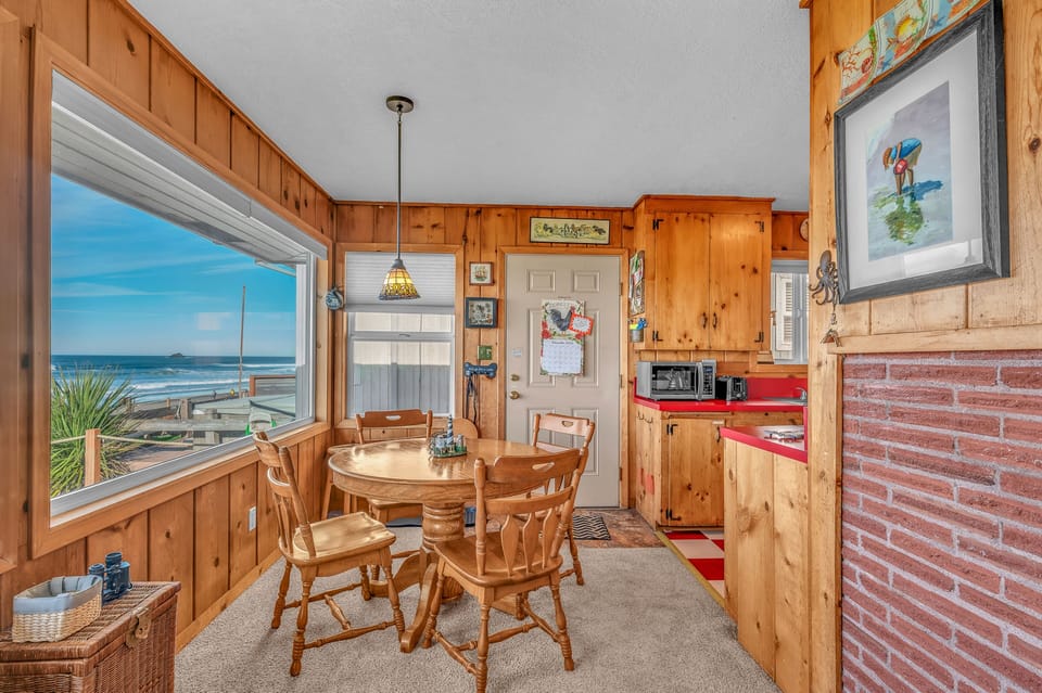 Savor meals at your charming dining table while ocean waves dance just outside your window in this cozy coastal retreat.