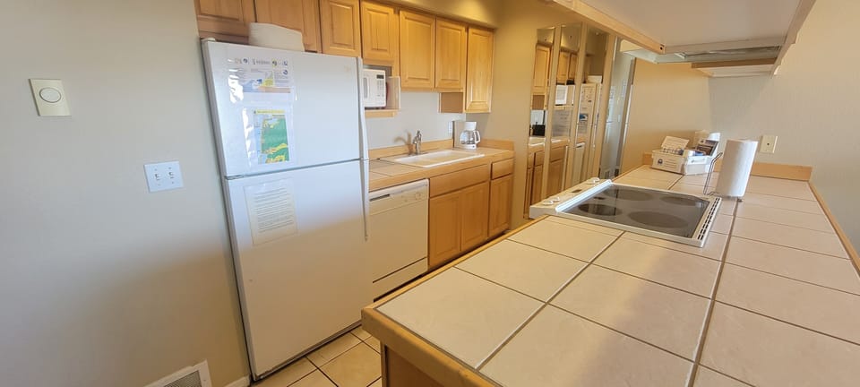 Your fully equipped kitchen offers everything you need to prepare fresh meals during your stay, with warm wood cabinets and ample counter space for cooking together.