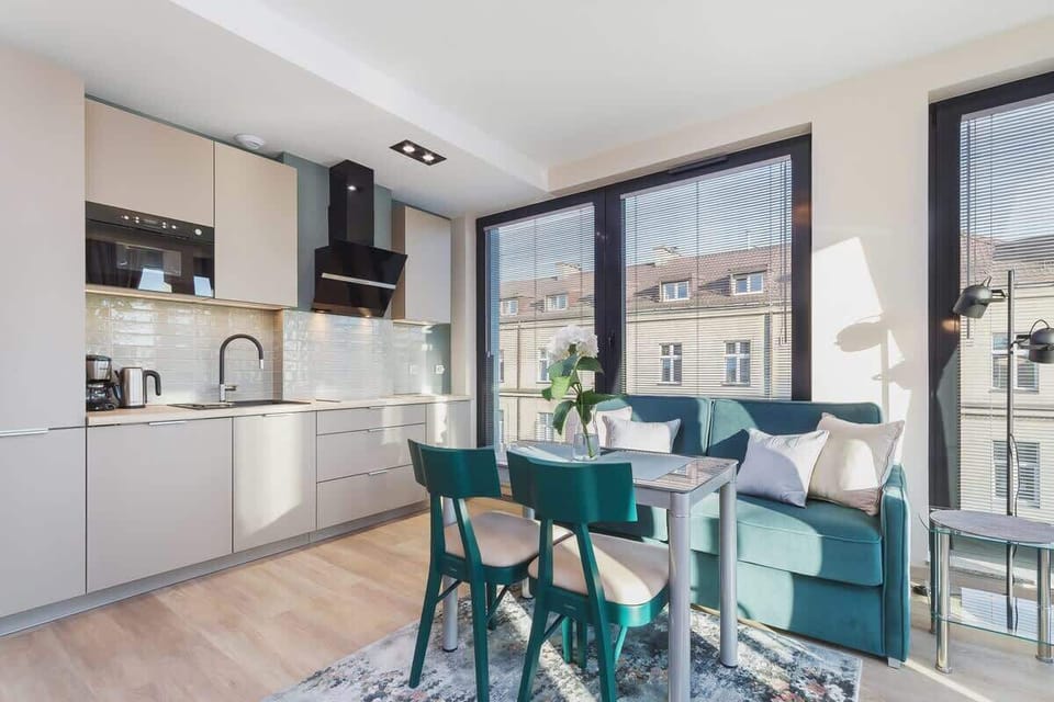  A modern kitchenette with white cabinets, integrated appliances, and a sleek backsplash. The space is compact yet functional, perfect for quick meal preparations.