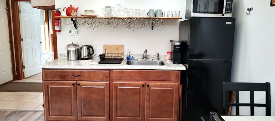 Kitchenette with Keurig, pods, microwave and tea kettle.