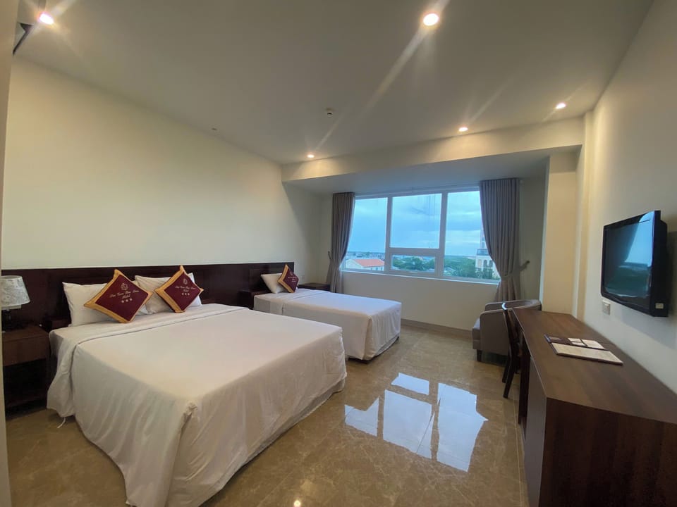 Deluxe Triple Room | Minibar, desk, laptop workspace, blackout drapes