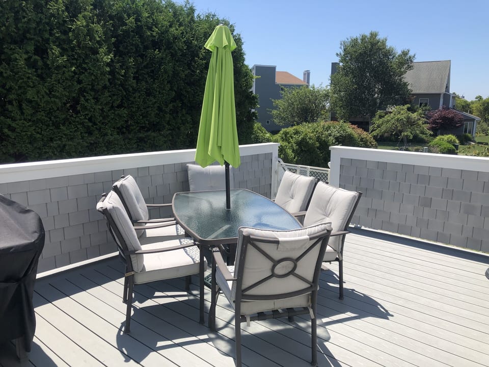 Main deck with grill, dining table, Adirondack chairs, and sectional