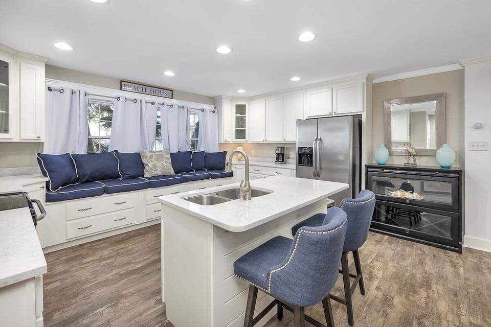 White kitchen with navy window seat, island, stainless appliances
