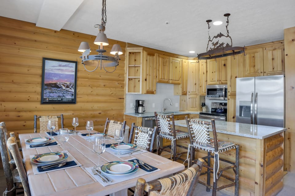 The kitchen and dining area with seating at the island for two and for six at the dining table.