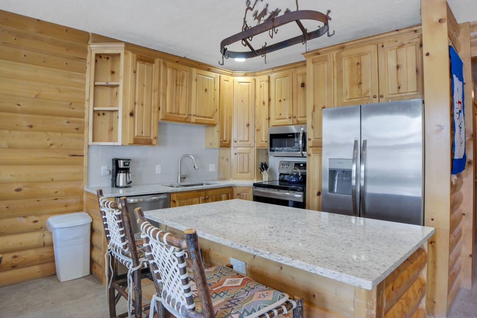 Comstock 203 offers a well equipped kitchen with stainless steel appliances, wood cabinets and island with seating for two.