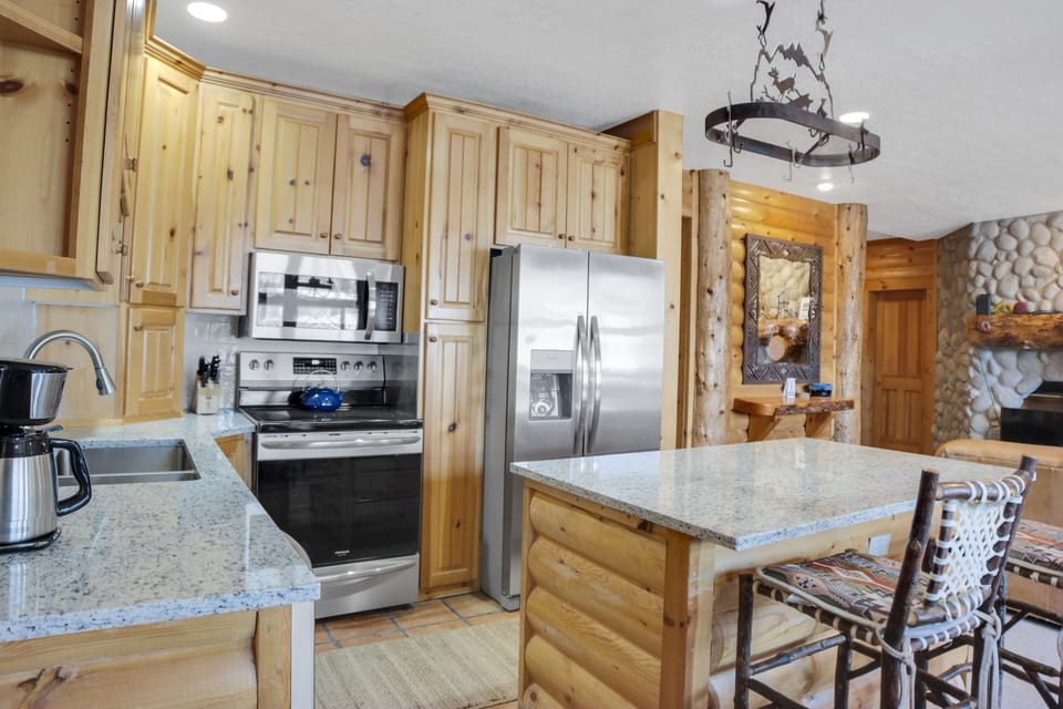 Comstock 203 offers a well equipped kitchen with stainless steel appliances, wood cabinets and island with seating for two.