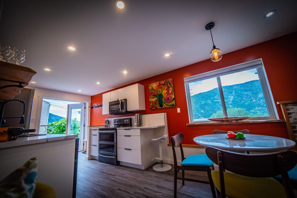 Spectacular open-concept kitchen and dining with vibrant red accent wall
