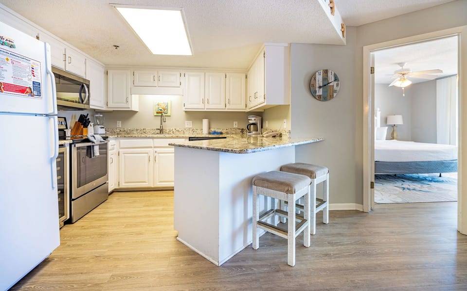 Kitchen featuring sleek stainless appliances, granite countertops, and a breakfast bar with seating