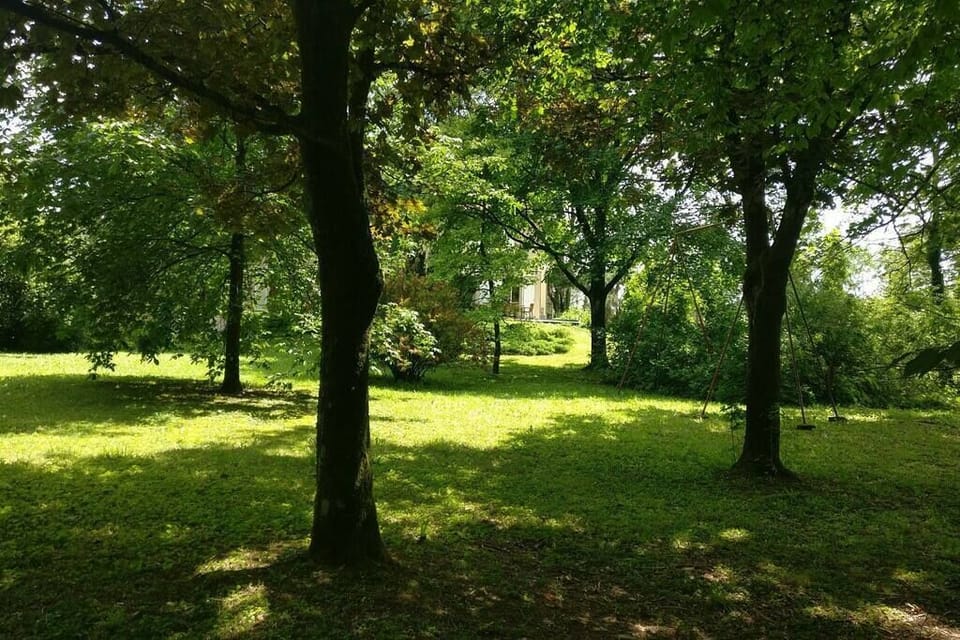 La maison vue du parc, assis sur un banc, un livre à porté de la main