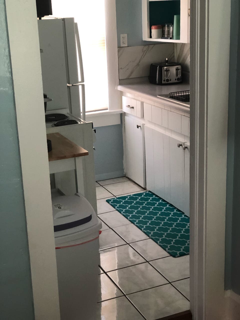 View into full kitchen. New 4 slice toaster and newer, full refrig. 