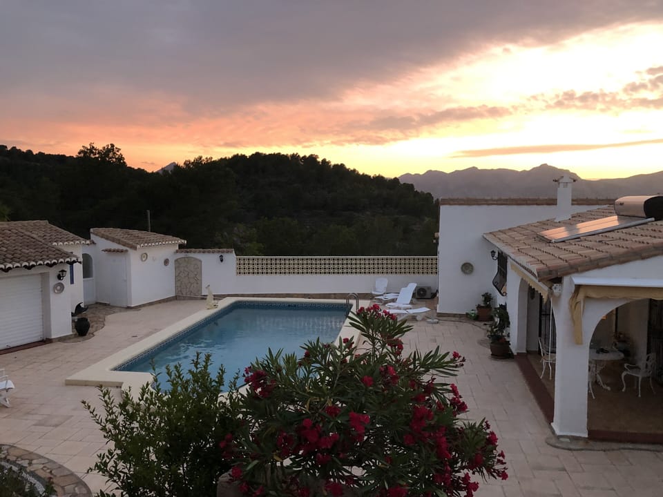 Sunset view from top terrace of pool and mountains
