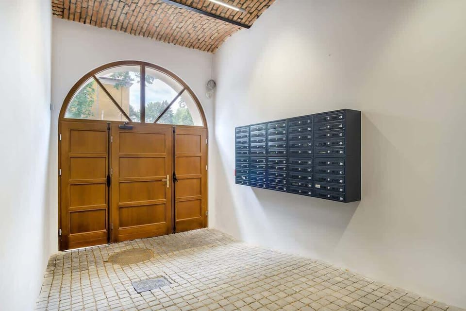 The building’s entrance lobby with an arched wooden doorway, mailboxes, and stylish flooring that enhances the welcoming ambiance.