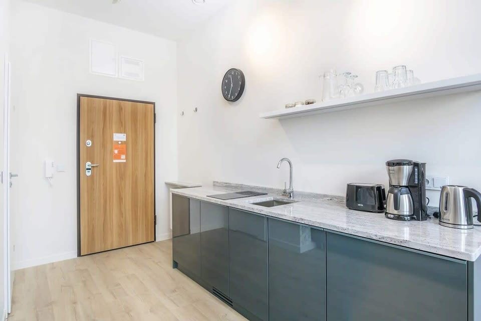 A cozy kitchenette with essential appliances, including a coffee maker and kettle, providing a convenient space for preparing light meals.