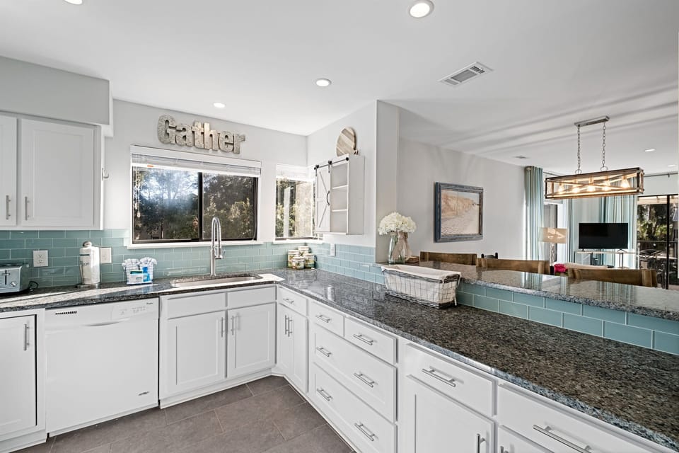 Whip up Lowcountry feasts in this bright, fully equipped coastal kitchen with granite counters, deep sink, and plenty of space for prepping fresh seafood or morning coffee, flowing seamlessly to dining and balcony views in your Hilton Head Island villa.