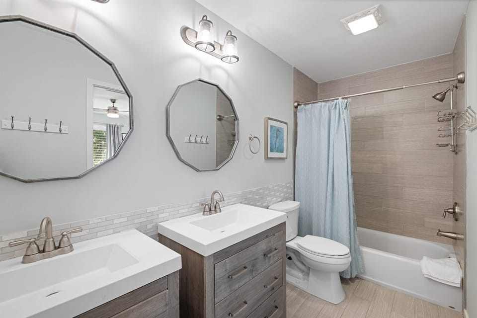 Master bathroom oasis on the main level: double vanities for shared ease, and a versatile bathtub/shower combo—blending style, comfort, and Lowcountry relaxation.