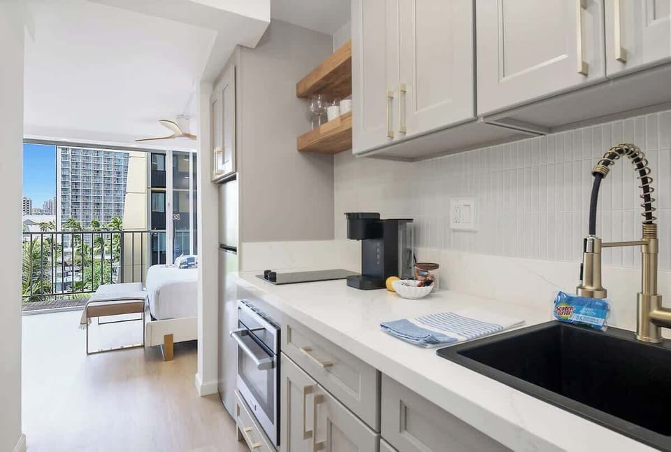A newly renovated kitchenette with a full-size refrigerator, a 2-burner stove, and a new Keurig coffee maker.