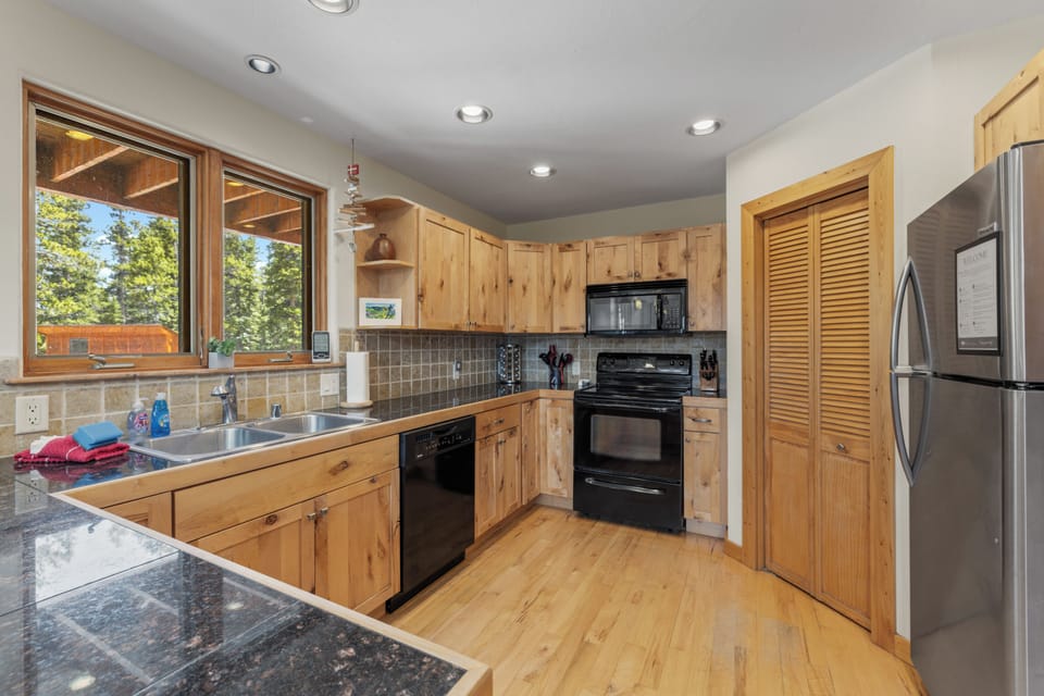 Plenty of counter room and cupboards are stocked with cooking utensils and serving supplies.
