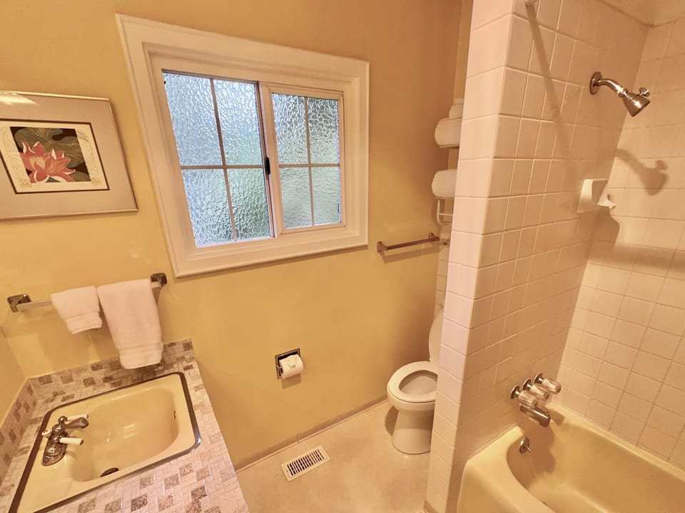 guest bathroom has tub/shower w/hand grip and taller comfort height toilet. 