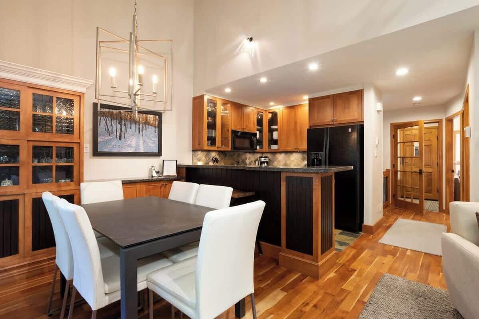 - Open dining area with warm lighting and modern wood finishes for cozy meals  
- Seats six comfortably for shared breakfasts or evening gatherings by the fire  
- Blends rustic charm with contemporary mountain home comfort and atmosphere 