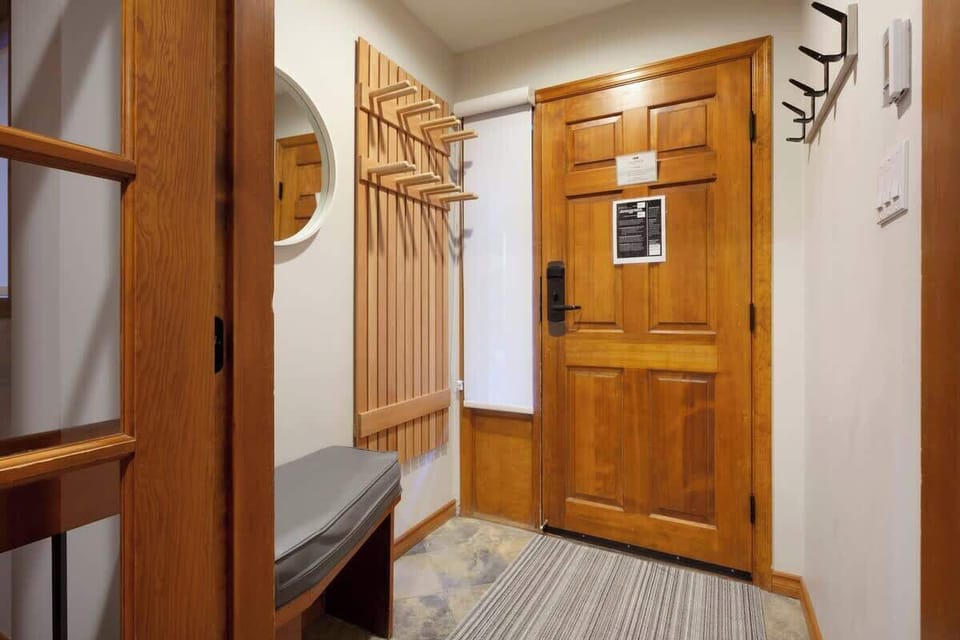 - Entryway with wooden finishes and bench seating for boots or ski gear storage  
- Hooks and shelving keep everything organized after a day on the slopes  
- Inviting mountain-style welcome as soon as you step through the front door  
