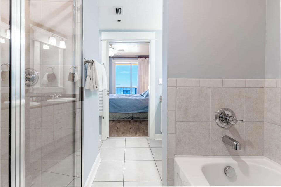 Unwind in your elegant ensuite bathroom featuring a glass shower and soaking tub, perfectly positioned between your bedroom retreat.