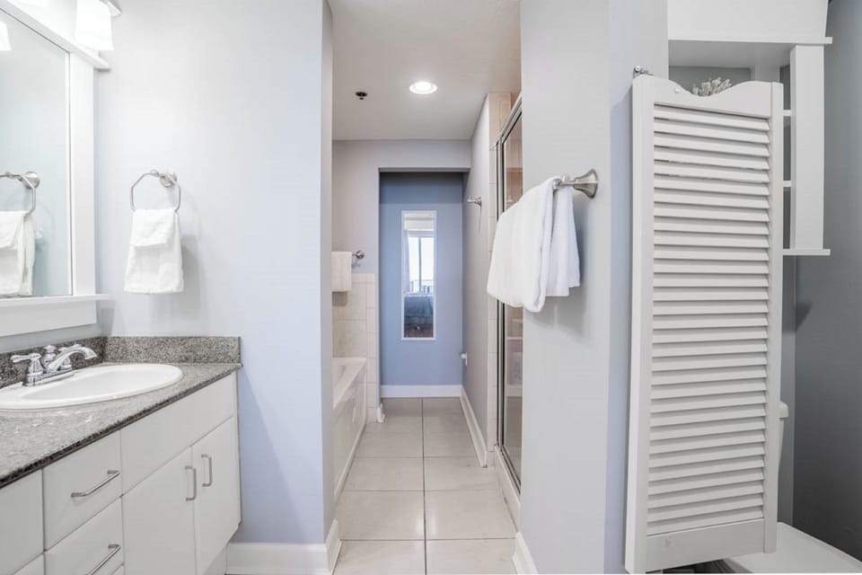 Your spacious bathroom features granite counters, crisp white cabinetry, and thoughtful touches like fresh towels ready for your arrival.