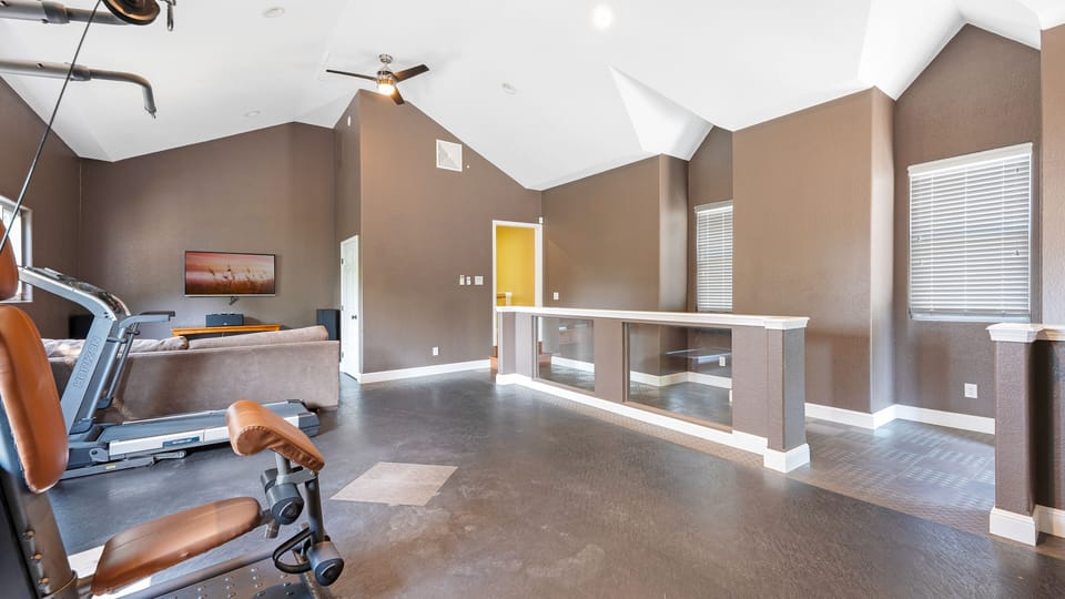 Workout/gym area and small living room with couch and cable TV