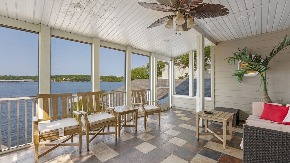 Giant screened-in porch off of the kitchen that leads down to the patio deck