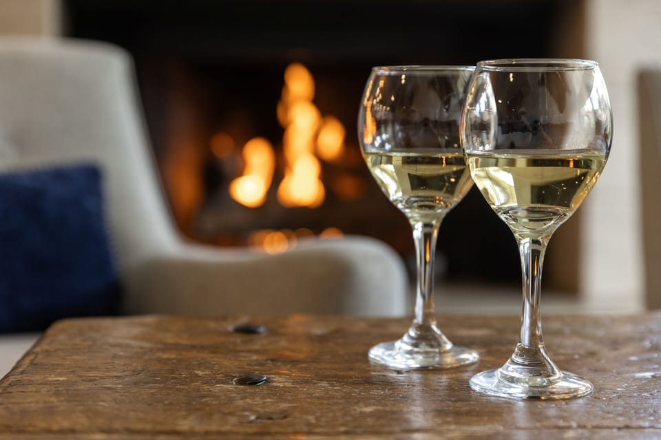 Unwind with a glass of wine beside your own cozy fireplace, where evenings invite you to relax and linger.