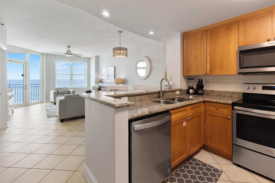Your fully equipped kitchen opens to a bright living space with stunning ocean views through floor-to-ceiling windows.